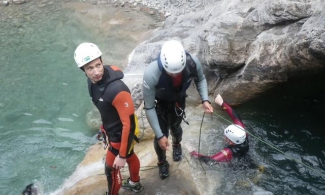  trois hommes surmonter les obstacles liés à la descente du lit d'une rivière 